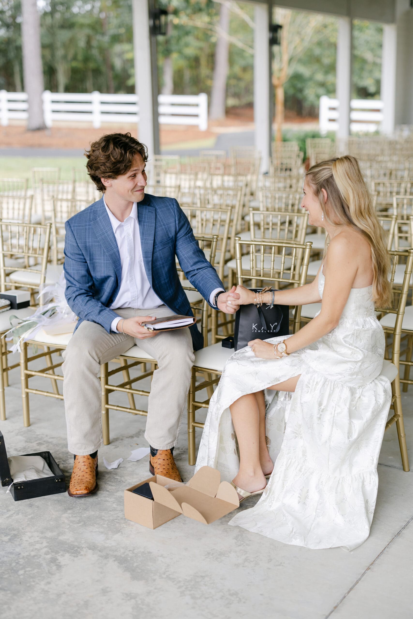 A couple exchanging wedding gifts while sitting where their wedding ceremony will take place.