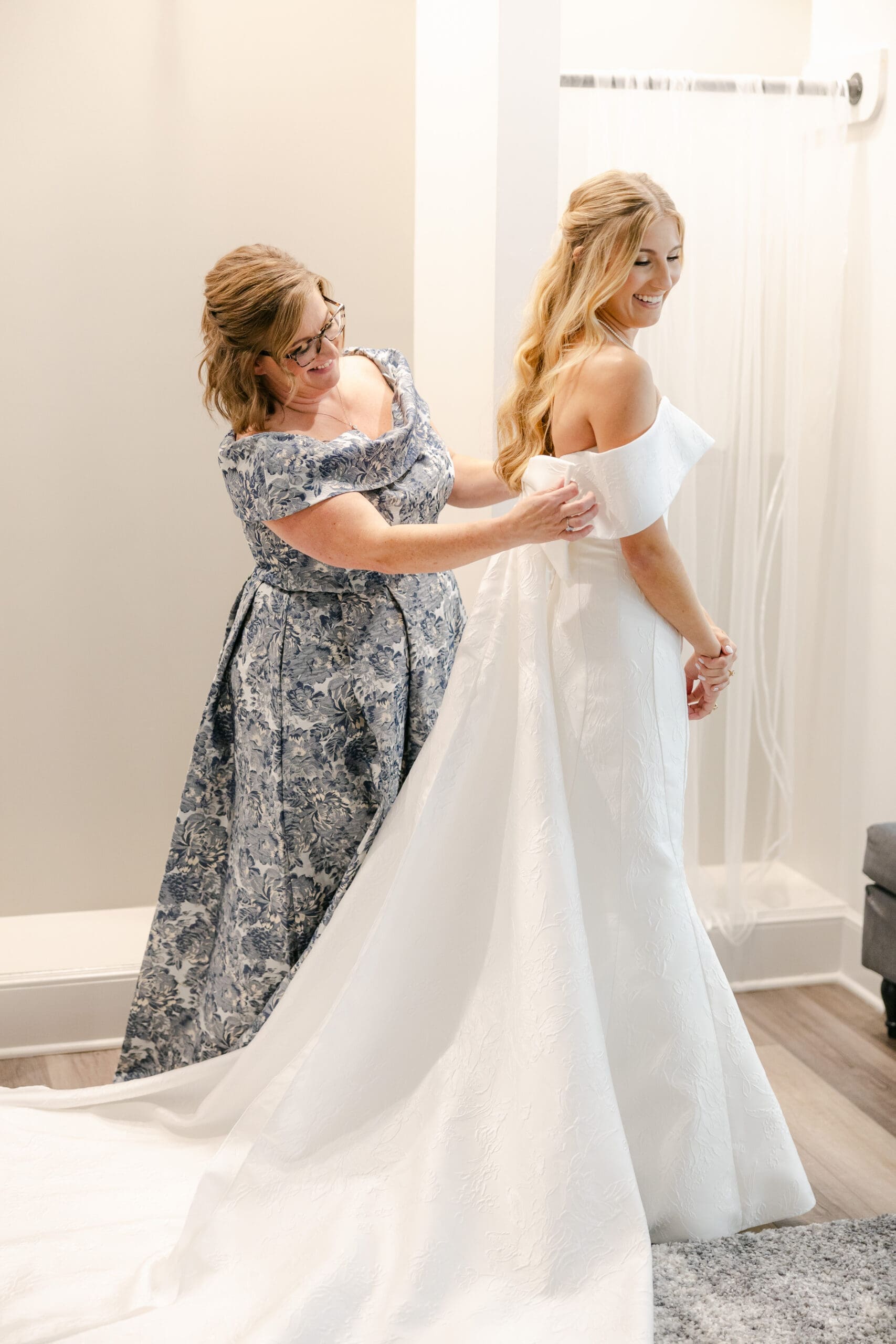A bride getting dressed with her mom helping her