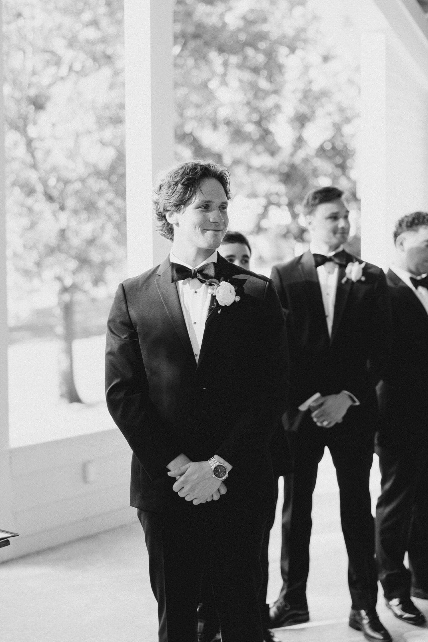 A black and white image of a groom seeing his bride for the first time.